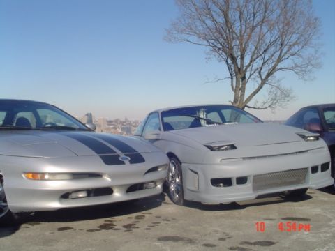 1995 Ford Probe - Two Ford Probes are parked outdoors under a clear blue sky.
