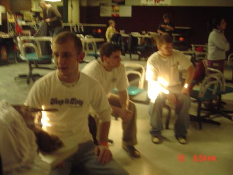 1995 Ford Probe - A group of people are gathered in a bowling alley, with tables and chairs visible in the background.