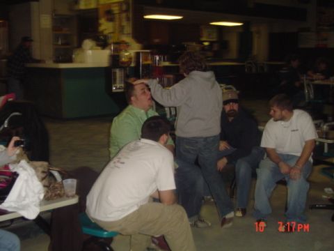 1995 Ford Probe - Several men are gathered in a room, with one person playfully touching another's forehead.