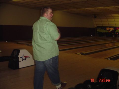 1995 Ford Probe - A man stands in a bowling alley, facing away from the camera, with bowling lanes stretching into the background.