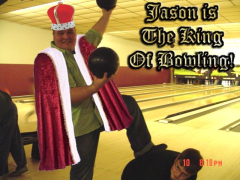 1995 Ford Probe - A man is dressed as royalty while holding bowling balls in a bowling alley.