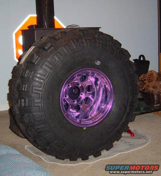 Oversized tire with purple chrome rim and Supermotors.net logo