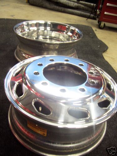 1999 Ford F-800 - Two polished aluminum heavy-truck wheels stood on a shop floor, the front one showing its 10-lug hub-piloted bolt circle and oval hand-hole…