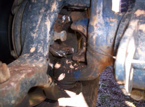 1995 Ford Bronco - This image shows a close-up view of heavily soiled and rusted vehicle suspension components.