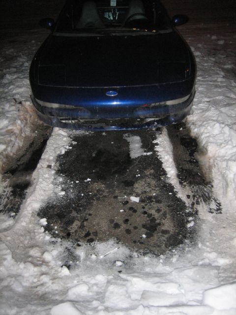1995 Ford Probe - A blue car with pop-up headlights is partially covered in snow.