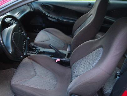 1995 Ford Probe - The interior of the car shows the front seats, center console, and dashboard area.