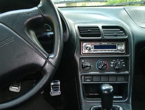 Interior of a 1995 Ford Probe showing the dashboard, steering wheel, and center console with an aftermarket stereo