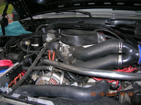 1996 Ford Bronco - Close-up view of a vehicle's engine bay, showing various hoses, wires, and engine components.