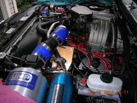 1996 Ford Bronco - Close-up of a modified engine bay, showing custom air intake and ignition components.