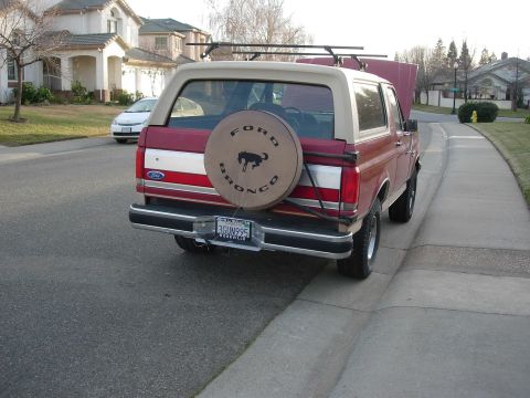 1990 Ford Bronco - This Ford Bronco is parked on a residential street with a spare tire mounted on the rear.