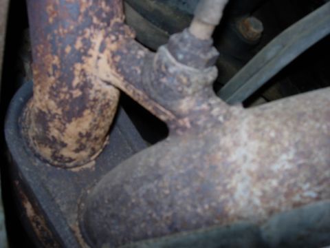1990 Ford Bronco - Close-up of a corroded exhaust pipe and sensor, with visible text from Supermotors.net.
