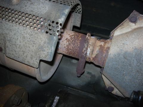 1990 Ford Bronco - Underside view of a vehicle's exhaust system, showing rusted pipes and a perforated heat shield.