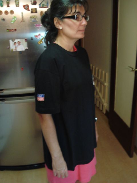 1986 Ford Bronco - A woman stands in a hallway, wearing a black t-shirt and pink shorts, with a refrigerator visible behind her.