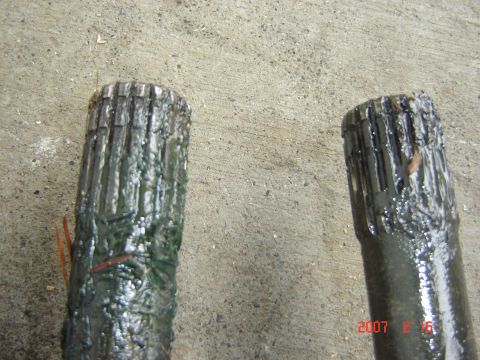 1993 Ford Bronco - Close-up view of two drive shafts, showing their splined ends covered in grease.