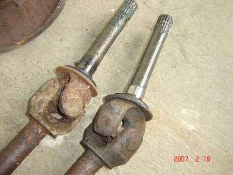1993 Ford Bronco - Comparison of a rusty CV axle with a cleaned one, showing the difference in condition.
