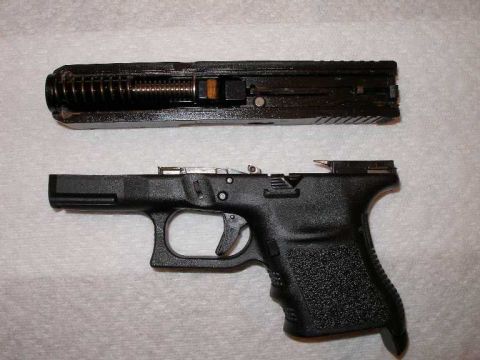 1998 Ford Crown Victoria - The slide and frame of a handgun are shown separated, indicating a disassembled firearm.