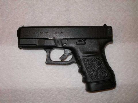 1998 Ford Crown Victoria - A black Glock pistol is shown on a textured surface.