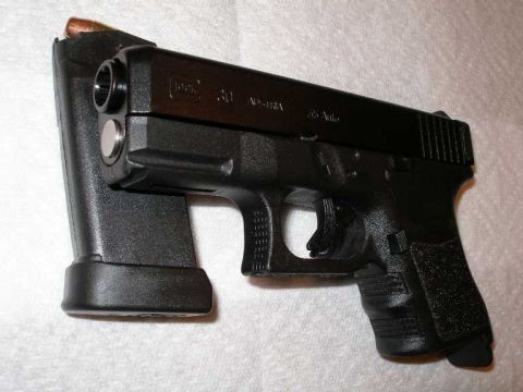 1998 Ford Crown Victoria - A Glock 30 pistol with a loaded magazine is shown in this close-up view.
