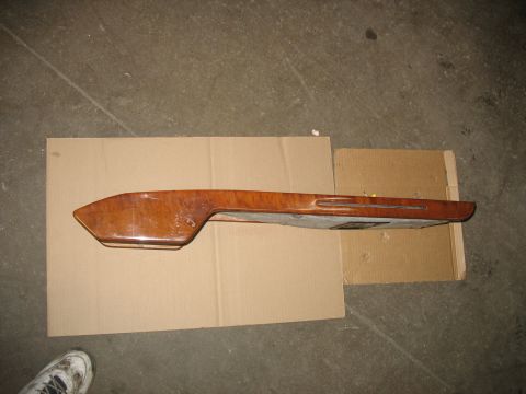 1995 Ford C-350 (Centurion Conversions) - Overhead console trim piece with wood-grain finish, placed on cardboard.