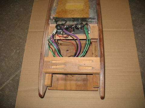 1995 Ford C-350 (Centurion Conversions) - The interior of a wooden overhead console shows a bundle of colorful wires connected to electronic components.