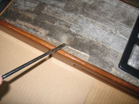 1995 Ford C-350 (Centurion Conversions) - Screwdriver being used to pry trim on a vehicle's overhead console.