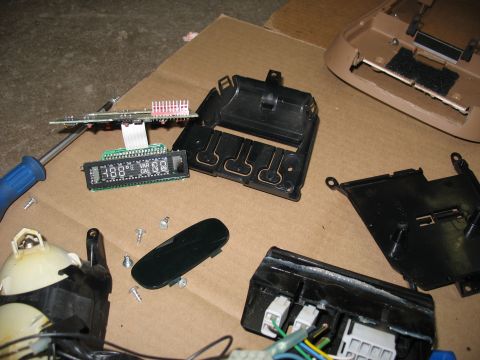 1995 Ford C-350 (Centurion Conversions) - Vehicle interior parts, including a digital display and circuit board, are disassembled on a cardboard surface.