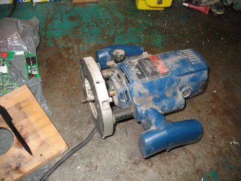 1995 Ford C-350 (Centurion Conversions) - A blue Ryobi router with a 1.75 HP label sits on a dirty floor next to a circuit board and a piece of wood.