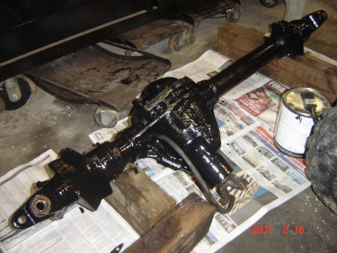 1993 Ford Bronco - Rear axle assembly painted black, with a can of paint and brush nearby.