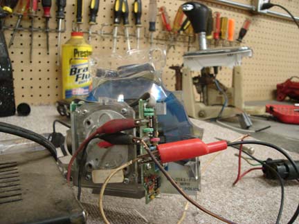 1992 Ford Crown Victoria - An automotive part is connected to wires and clips on a workbench with tools in the background.