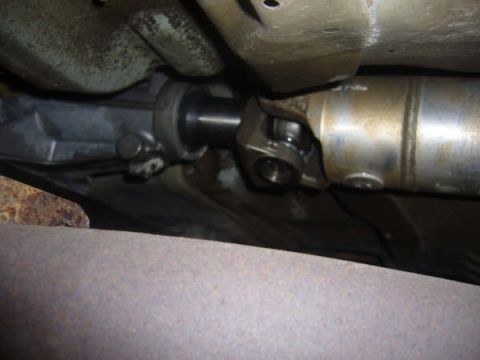 1996 Mercury Grand Marquis - Underside view of a vehicle's driveshaft and universal joint assembly.