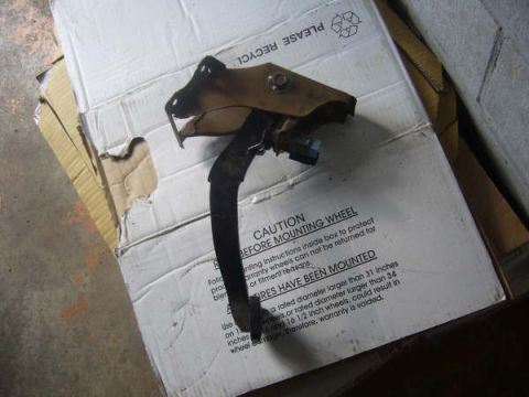 1996 Mercury Grand Marquis - A clutch pedal assembly is shown resting on a cardboard box with caution labels.