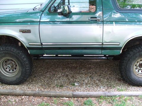 1996 Ford Bronco - Side profile of a 1996 Ford Bronco, highlighting its 'BRONCO' badging and installed rock sliders.