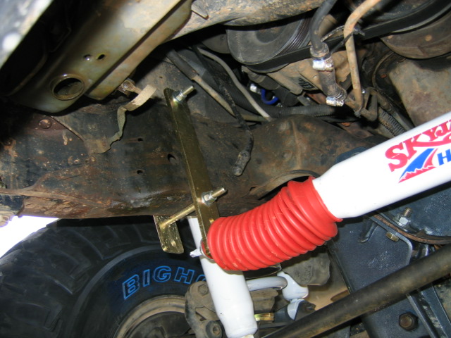 Undercarriage view showing a Skyjacker shock absorber with red boot and part of a tire with 'BIGHA' visible
