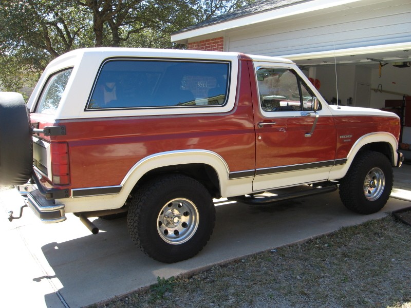 Red and white Ford Bronco parked in driveway