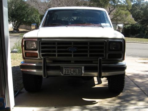 1986 Ford Bronco - Front view of a white Ford Bronco, showing its grille, headlights, and license plate.