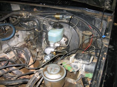 1986 Ford F-150 - Close-up view of an engine bay, focusing on the brake master cylinder and associated plumbing. The 'SUPERMOTORS' logo is visible in the low…