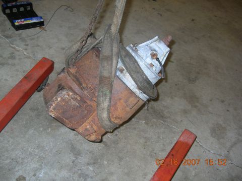 1991 Ford F-150 - A heavily rusted engine part is suspended by straps and chains, ready for removal or installation.