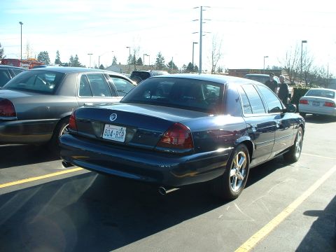 2000 Ford Crown Victoria - Rear view of a dark blue 2000 Ford Crown Victoria in a parking lot with another car.