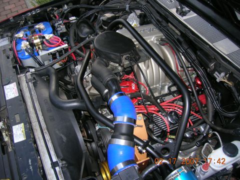 1996 Ford Bronco - Close-up view of a modified engine bay with prominent aftermarket parts and wiring.