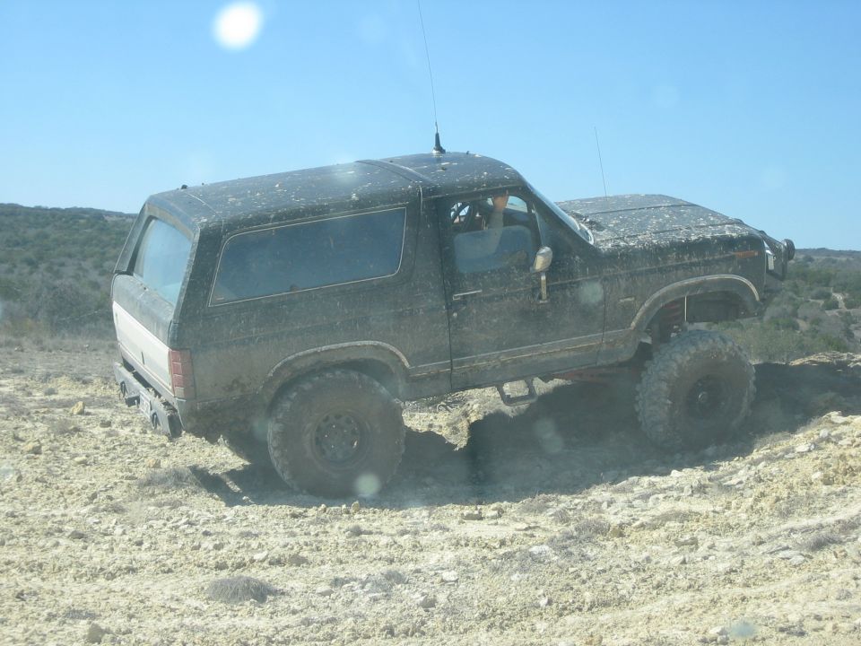 Black 1996 Ford Bronco on a dirt trail, side view