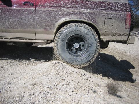 1996 Ford Bronco - This 1996 Ford Bronco is covered in mud, showing its off-road capabilities on a dirt track.