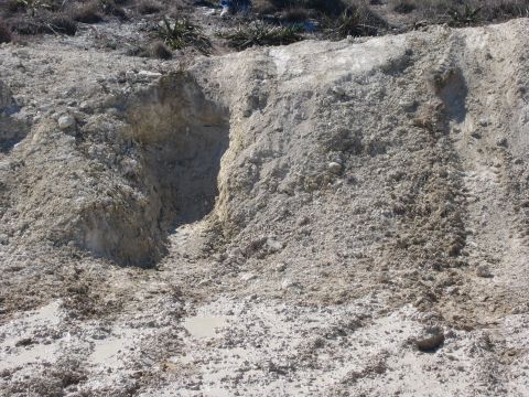 1996 Ford Bronco - A natural formation of dirt and rock shows erosion patterns and a small cave-like opening.