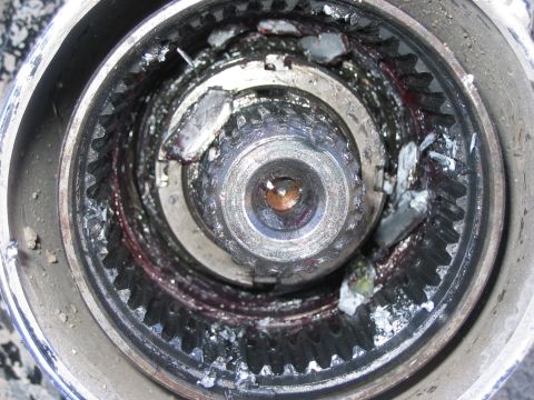 1996 Ford Bronco - This wheel hub assembly shows significant damage to its internal gears and appears to be packed with old grease.