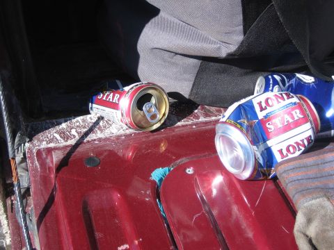 1996 Ford Bronco - Empty beer cans are visible on the red surface of what appears to be a vehicle's cargo area.
