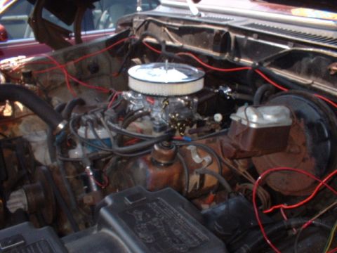 1979 Ford Bronco - Close-up of an engine bay with various components visible, including the carburetor and brake booster.