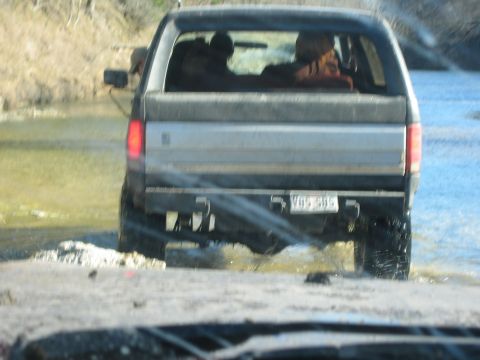 1996 Ford Bronco - The rear of a 1996 Ford Bronco is seen as it drives through a shallow body of water.