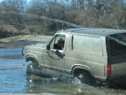 1996 Ford Bronco - A Ford Bronco navigates a muddy, watery terrain.