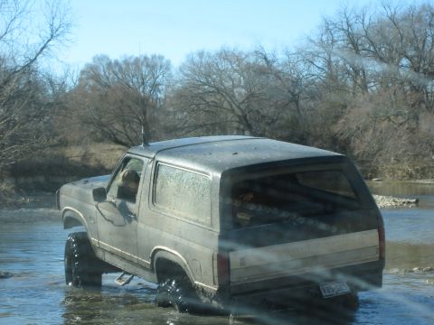 1996 Ford Bronco - This 1996 Ford Bronco navigates through a shallow river, its tires deep in the water.