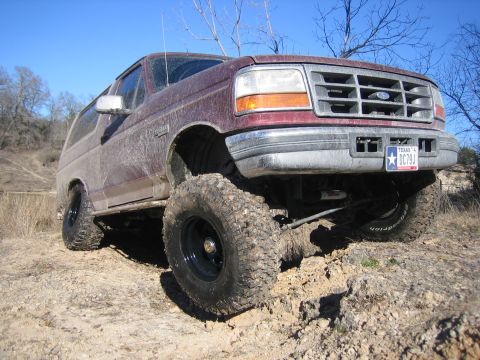 1996 Ford Bronco - This lifted Ford Bronco is shown off-road on a sunny day with a clear blue sky.