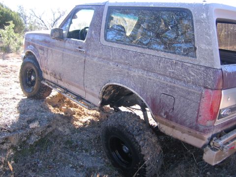 1996 Ford Bronco - This SUV is covered in mud after driving off-road.